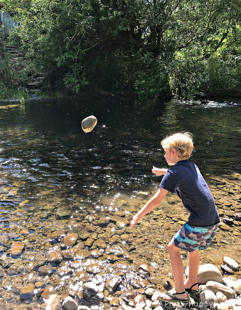 boy throwing rock in creek finding natural rock soap dish