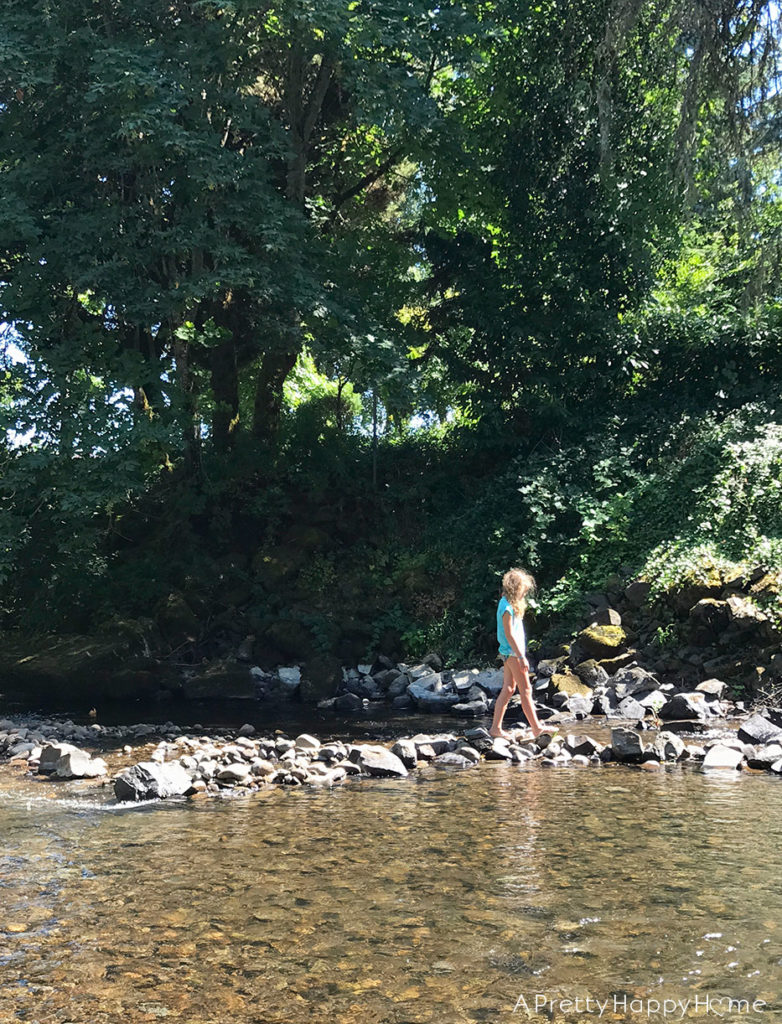 girl playing in creek finding natural rock soap dish 