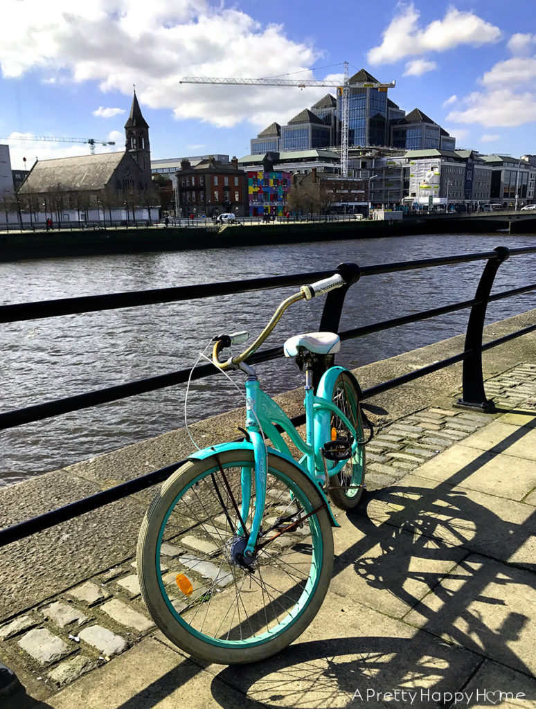 turquoise bike parked along the liffey river in dublin