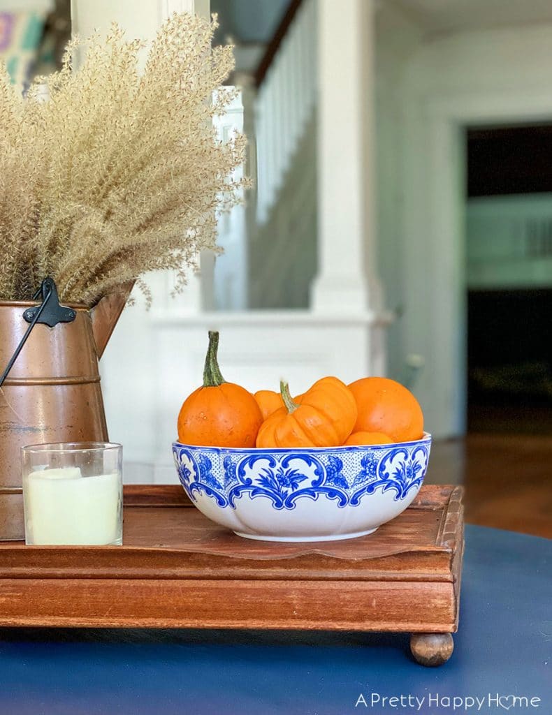 fall coffee table with blue accents 5 Fall Decorating Tricks To Give Your Home Cozy Vibes decorate with a bowl of pumpkins