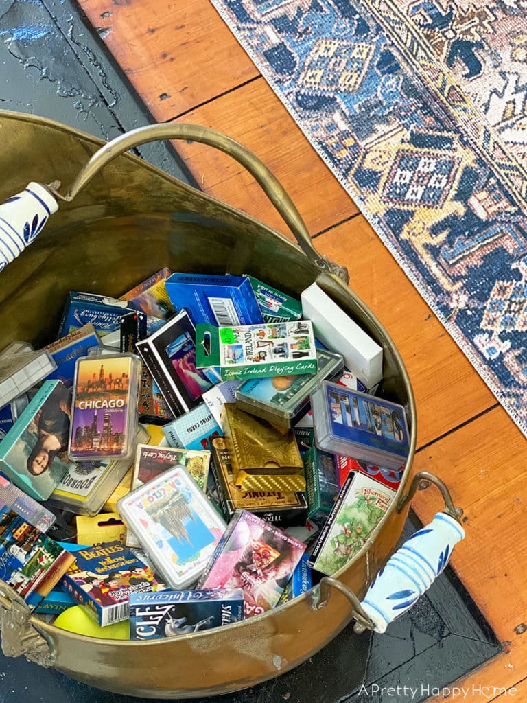decks of playing cards collected while traveling as a souvenir displayed in a brass ash bucket on the happy list