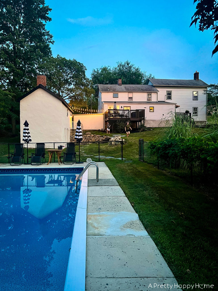 Adding To Our Concrete Pool Deck Ourselves pool at night behind a colonial farmhouse