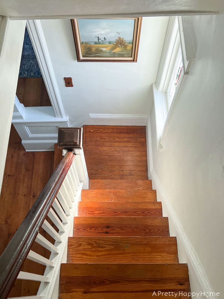 Candid Photos of Our House That Give Me Warm Fuzzy Feelings colonial farmhouse staircase bathed in warm light from sunset
