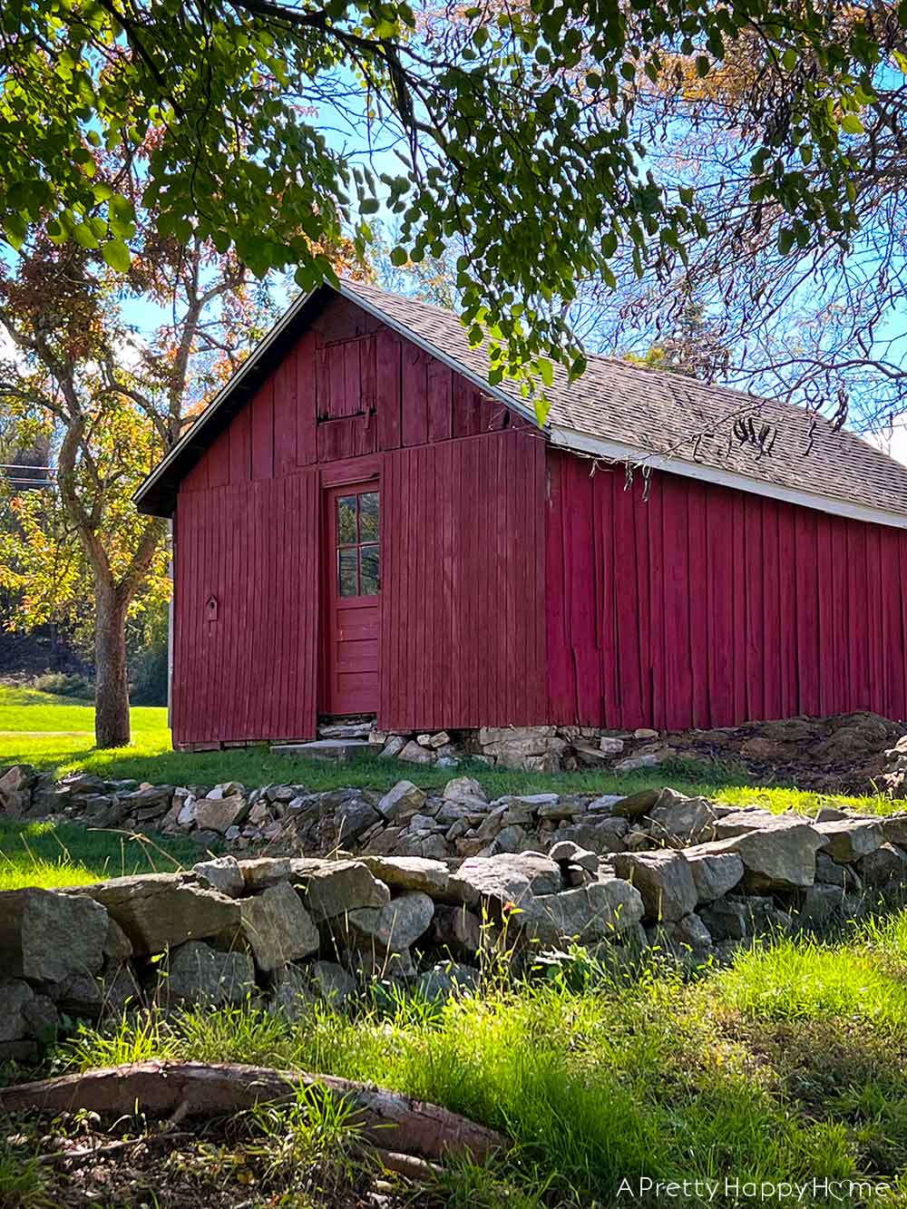 low fieldstone walls around a red barn