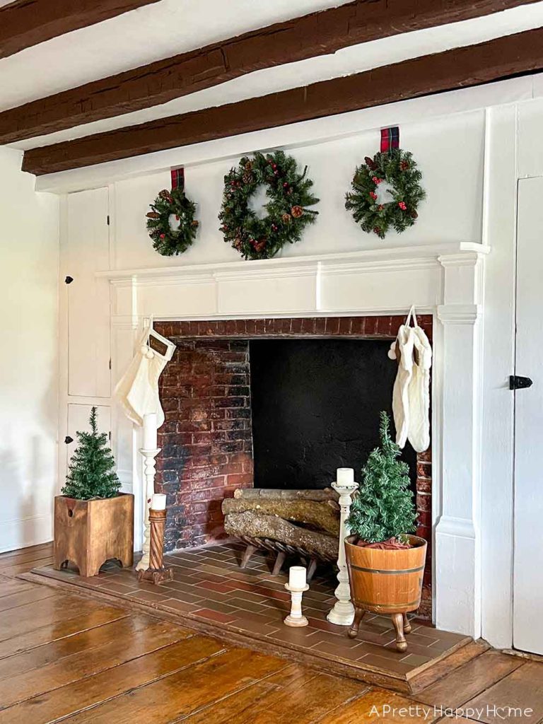 christmas mantel with three wreaths in a colonial era house