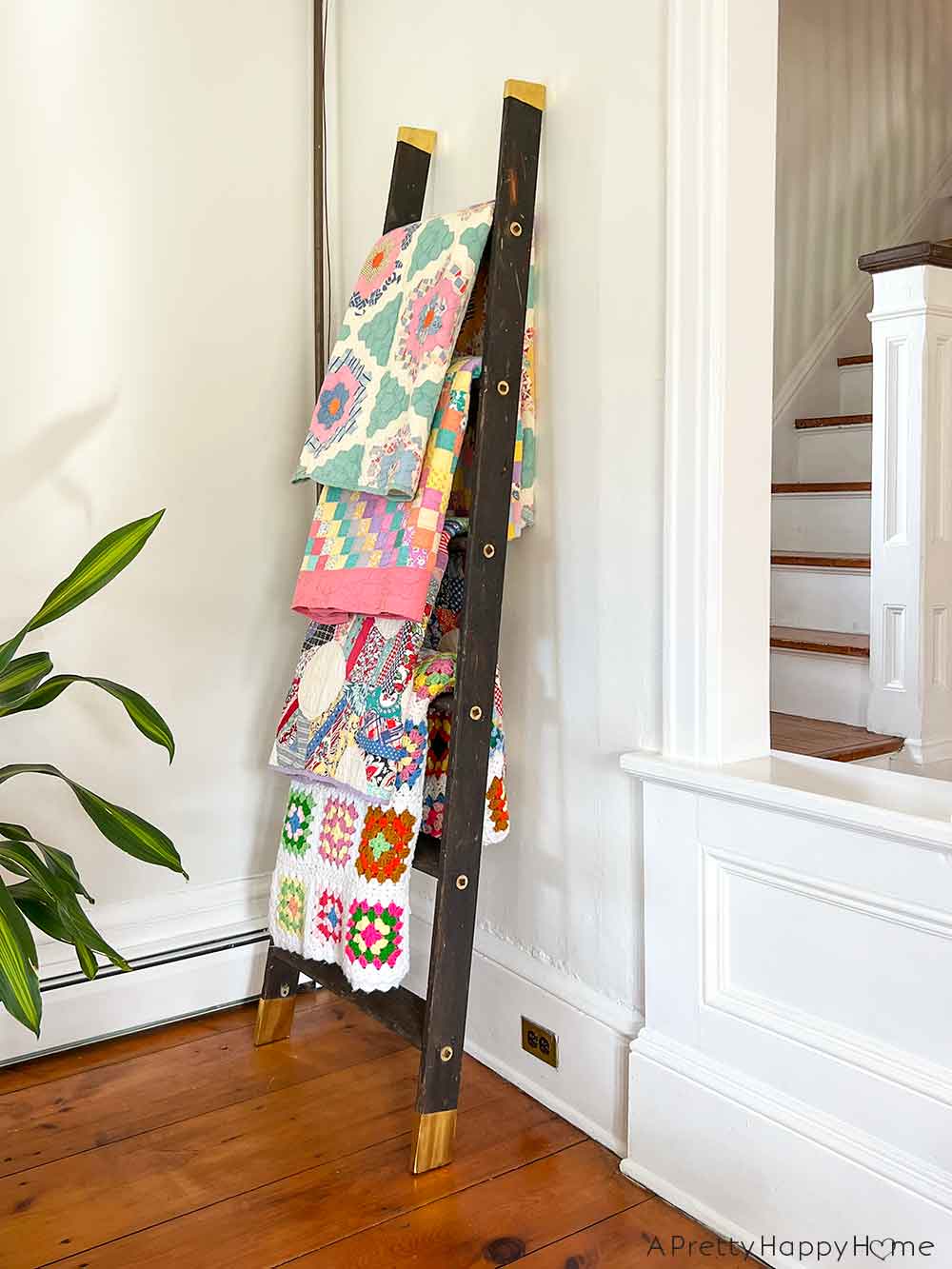 Turn An Old Wood Ladder Into A Blanket Ladder by removing the top cap and adding brass leg tips