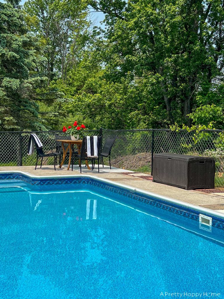 Adding To Our Concrete Pool Deck Ourselves pool seating with black chairs and black and white striped towels