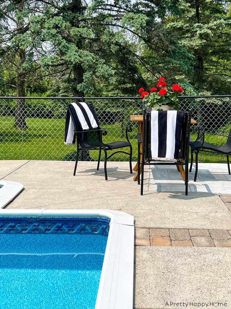 painted metal pool coping using marine grade paint by rustoleum set on a back ground with black chairs and black and white striped pool towels