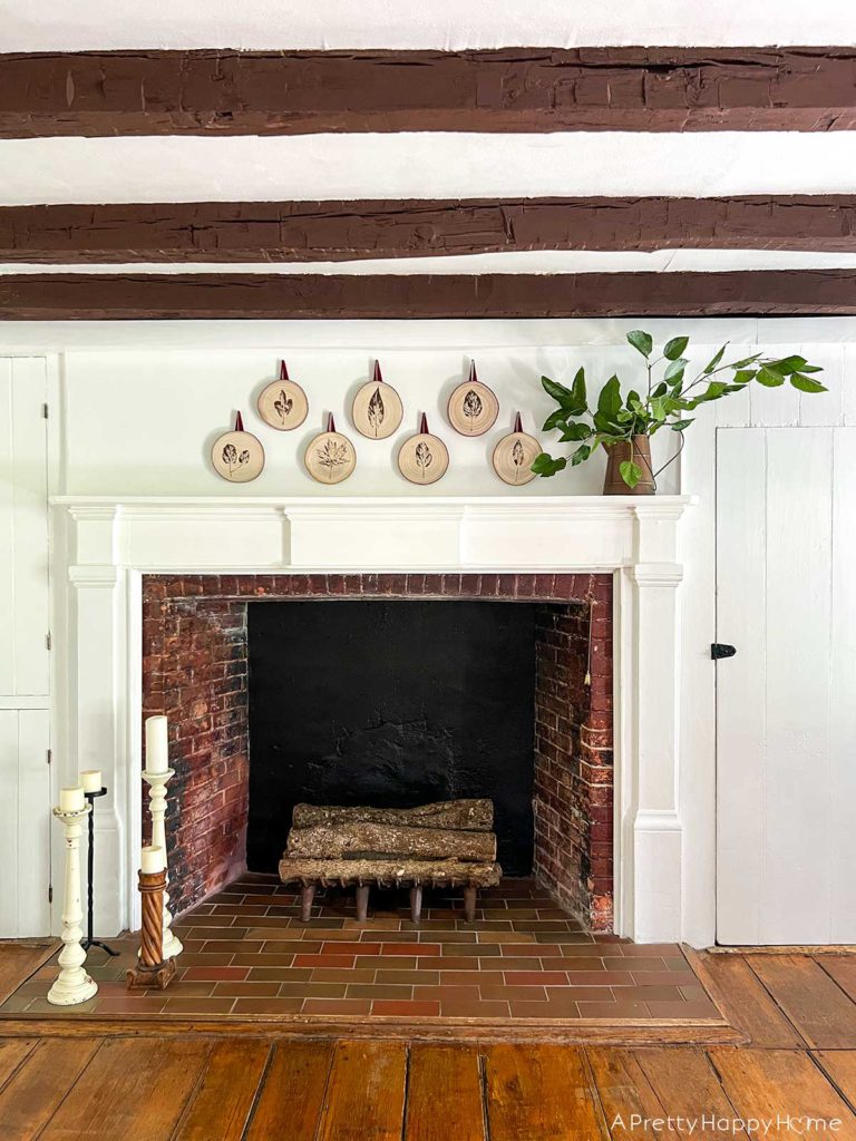 Fall Mantel With Leaf-Stamped Wood Rounds in a colonial era home with wood beams and original wood floors fall decorating ideas