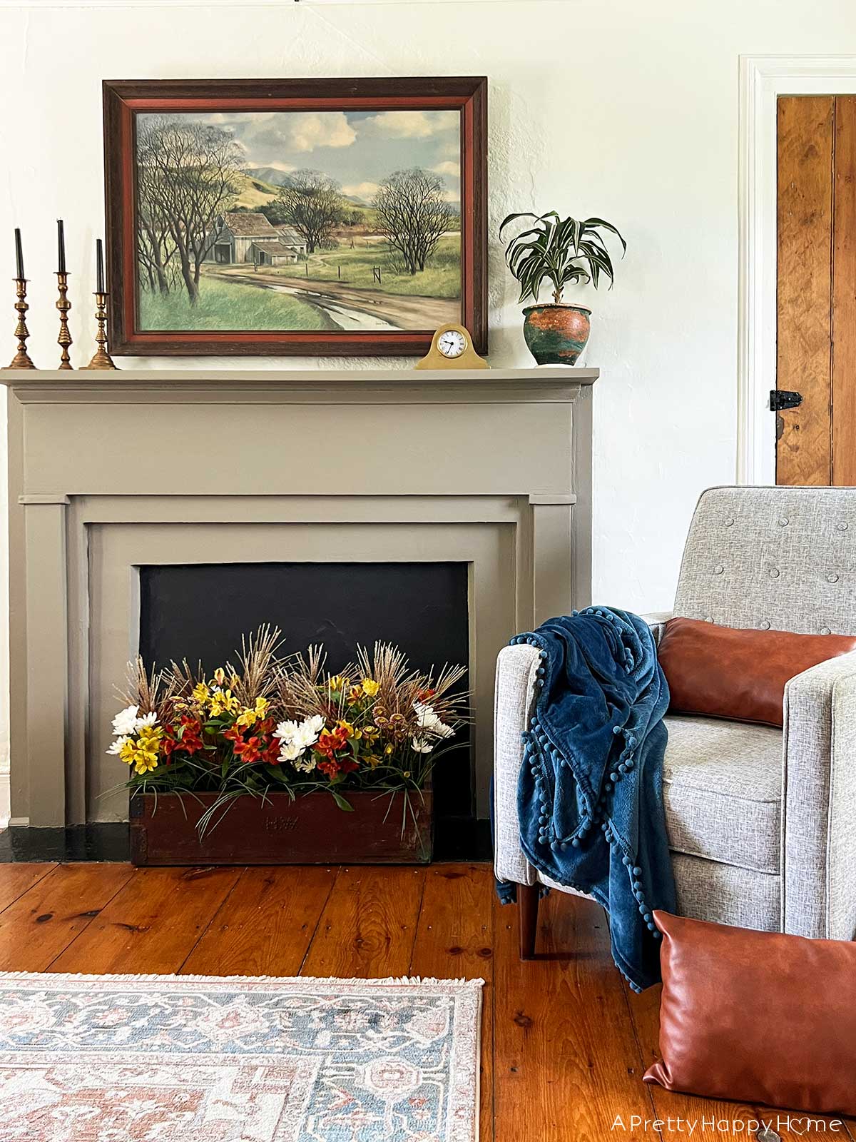 fall flower arrangement in tool box in front of a fireplace in a colonial farmhouse 