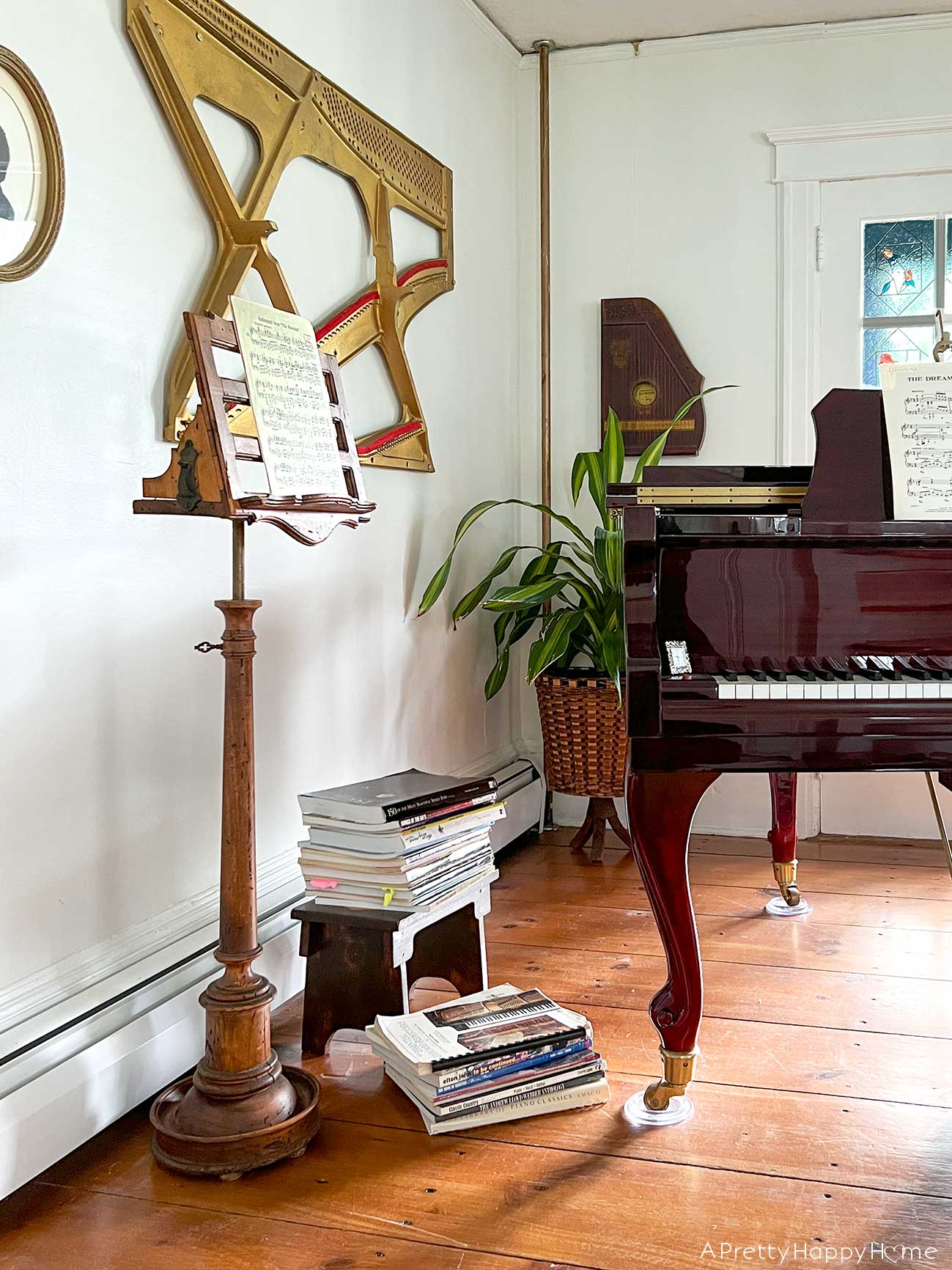 My Latest Thrift Store Finds: a wood music stand featured in a music room with a baby grand piano and vintage instruments
