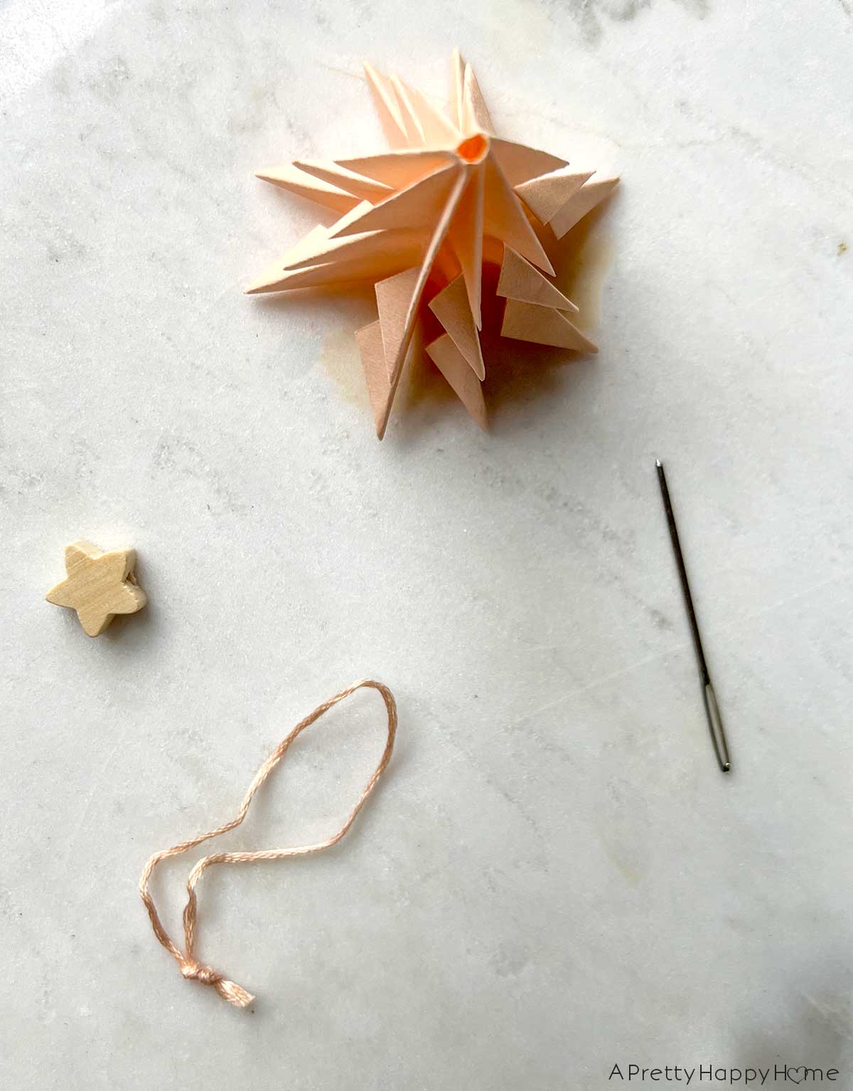 paper tree ornaments with wood star toppers fold paper tree ornaments using a wood star bead as the tree topper