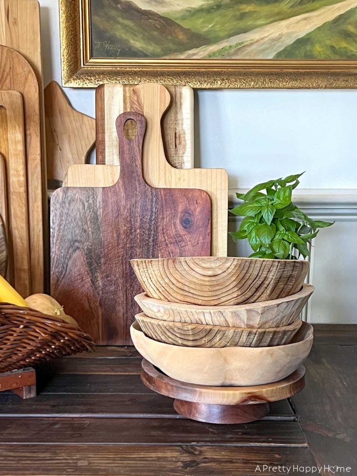 Wood Bowls: For Food or Decor? stack of wood bowls in front of wood cutting boards in a farmhouse kitchen
