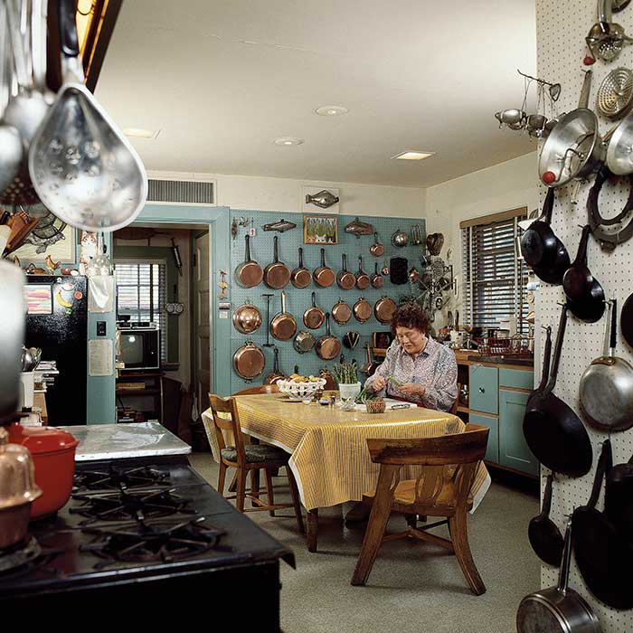 julia child in her kitchen with blue peg board photo by jim scherer via bon appetit on the happy list