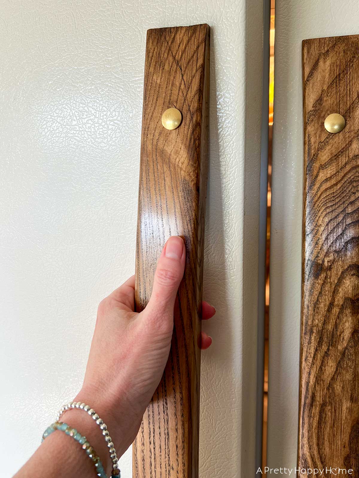 DIY Curved Wood Refrigerator Handles with brass accents on an old fridge
