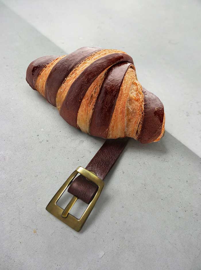 dudi ben simon visual pun photography chocolate croissant with leather belt via this is colossal on the happy list
