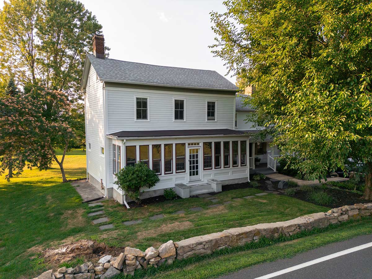 white colonial farmhouse exterior with sunporch