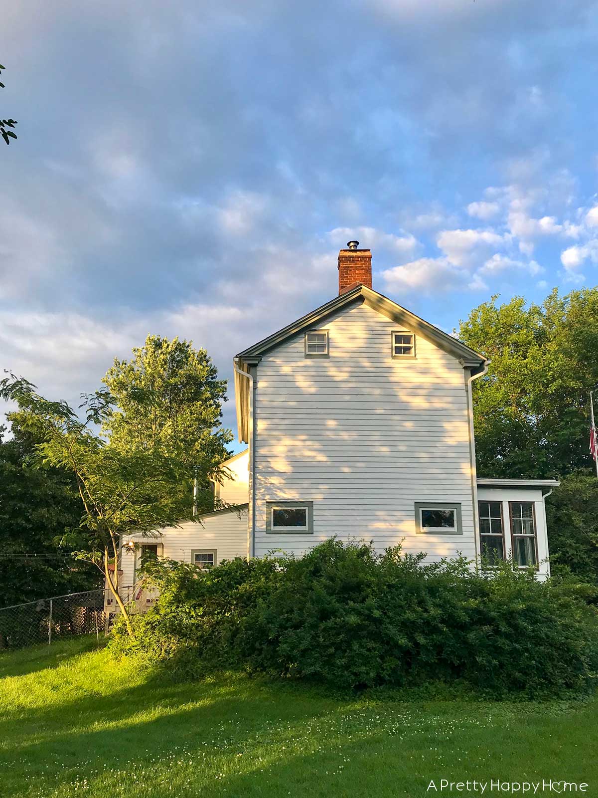 white colonial farmhouse exterior with sunporch