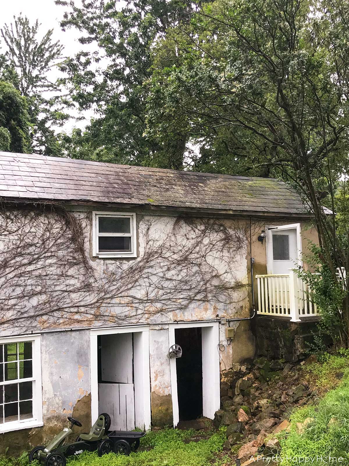 fieldstone porch made with fieldstone and lime mortar skimmed over concrete on a 250-year-old carriage house BEFORE PHOTO