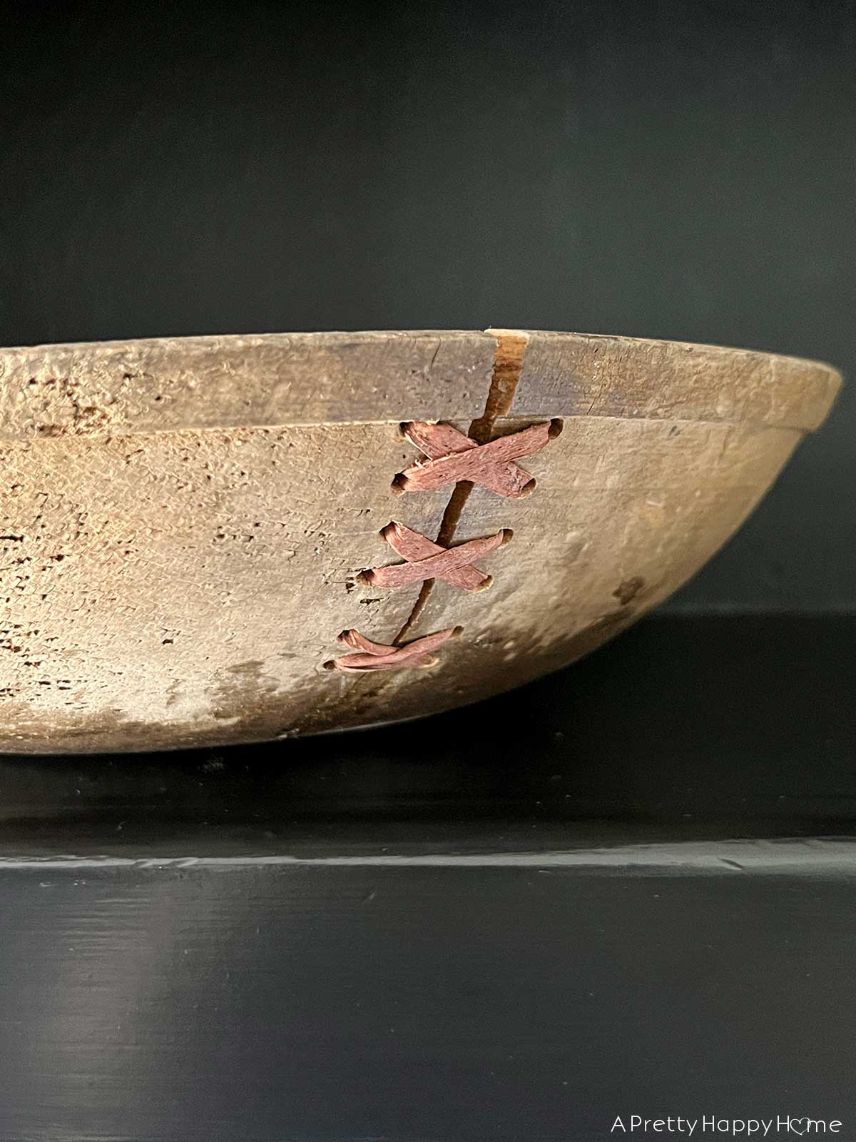 creative way to fix a cracked wood bowl with leather laces 