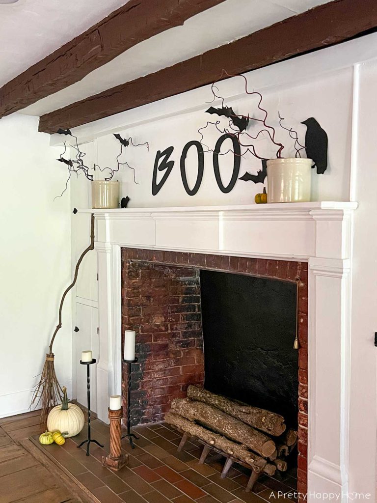 boo halloween mantel with hand painted boo sign, paper bats, and branches inexpensive halloween decor with paper bats, birds, and mice