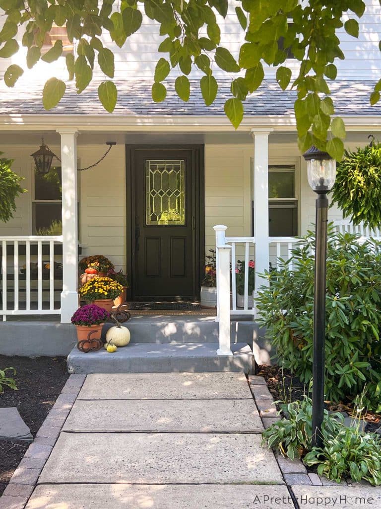 Fall front porch porch decorated for fall with paint blue ceiling natural rug and fall flowers