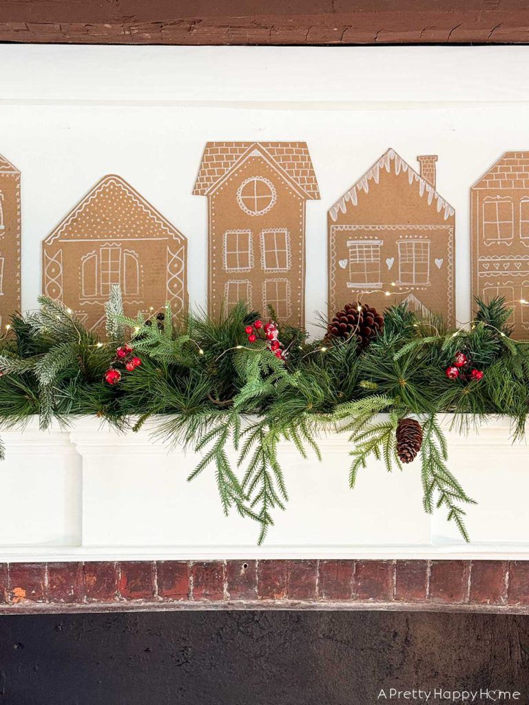 Three Christmas Fireplaces fireplace decorated with garland and cardboard gingerbread houses