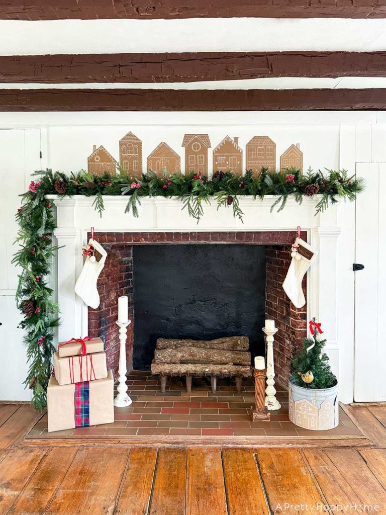 Three Christmas Fireplaces fireplace decorated with garland and cardboard gingerbread houses