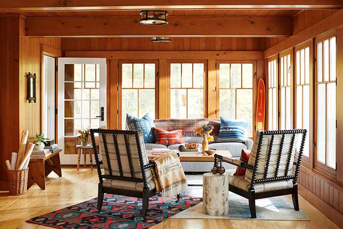 oleary wisconsin cabin sitting room with knotty pine paneling photo by Josh Grubbs, styling by Lisa Evidon, for Country living on the happy list