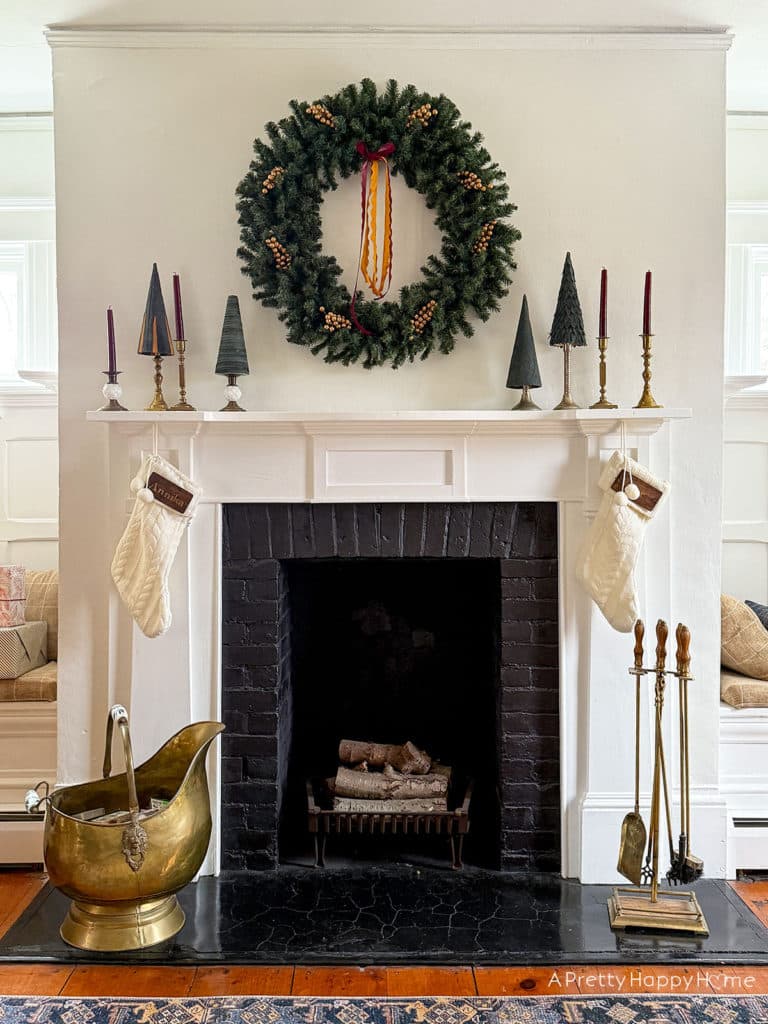 Three Christmas Fireplaces fireplace decorated with wreath and green christmas trees