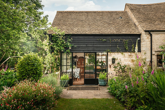 unique home stays photo of a home in england with black siding and stone patio on the happy list