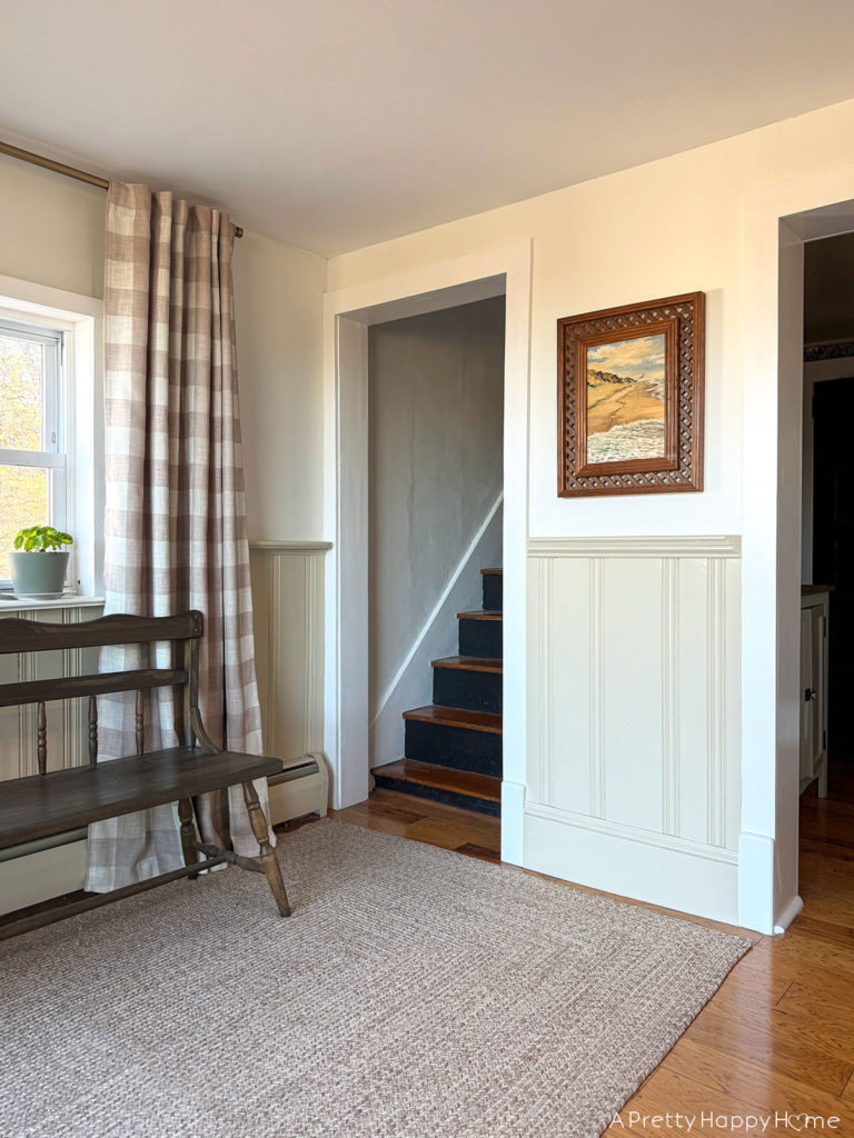 farmhouse kitchen with off white wainscoting and black stairs