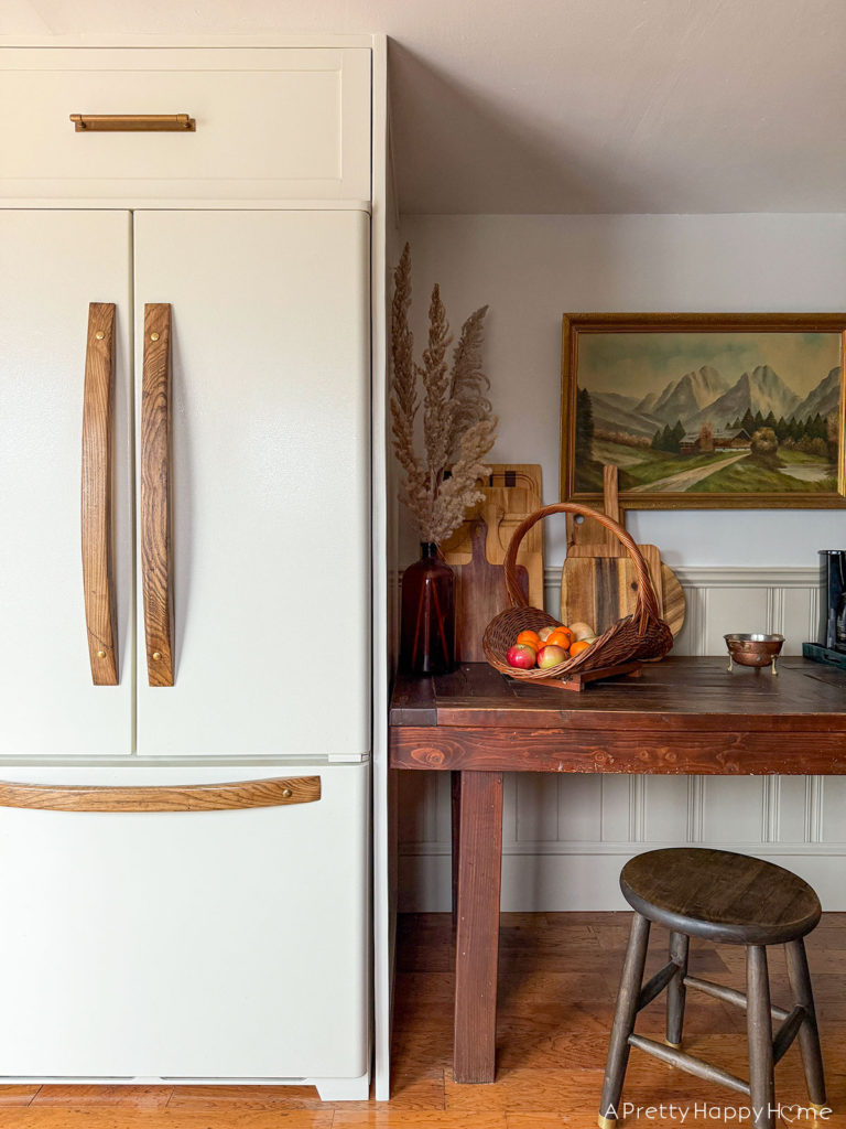 building in an old fridge to make it look custom and panel ready. refrigerator with wood handles and cabinet feet. refrigerator with slide out drawer above fridge. how to customize an old refrigerator.