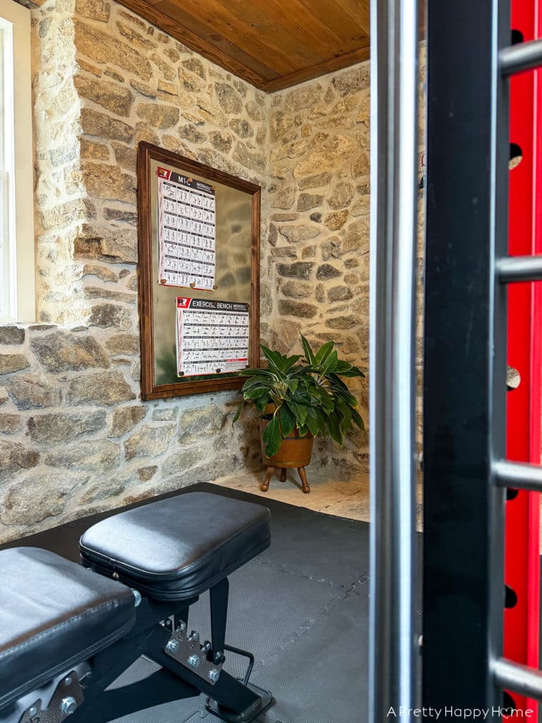 magnetic bulletin board made with sheet metal hung on a stone wall in a home gym