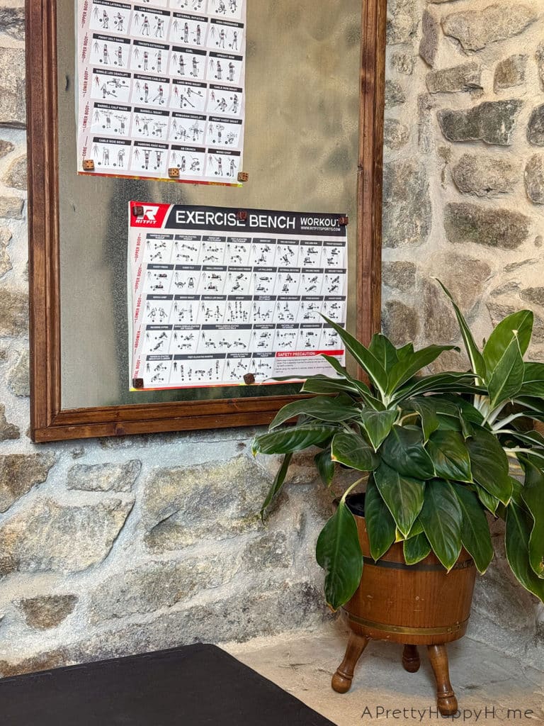 magnetic bulletin board made with sheet metal hung on a stone wall in a home gym