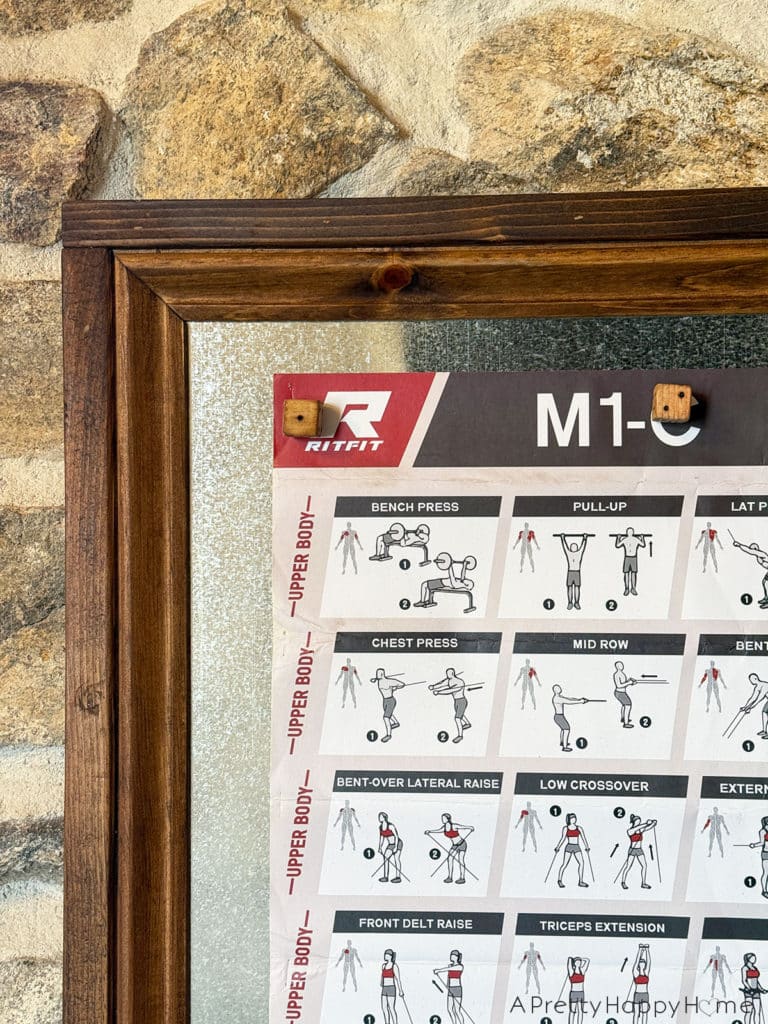 magnetic bulletin board made with sheet metal hung on a stone wall in a home gym wood dice magnets