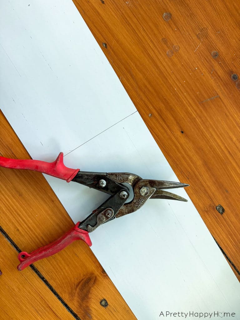 DIY Copper Toe Kick For Built-In Desks to solve the problem of feet scuffing the trim using adhesive copper toe kick cut with metal snips