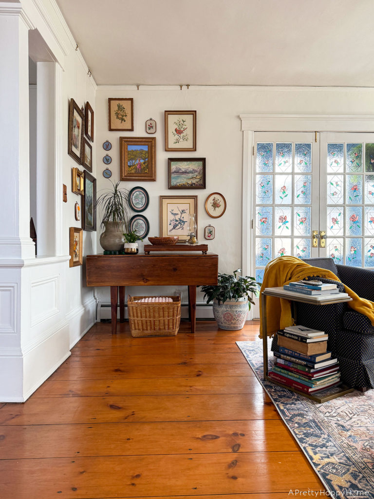 nature art gallery wall with paintings and embroidery next to stained glass doors gallery wall wrapping a corner