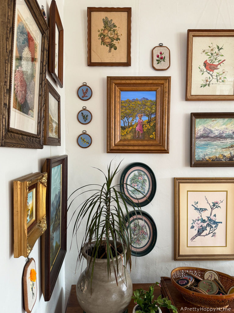 nature art gallery wall with paintings and embroidery next to stained glass doors gallery wall wrapping a corner