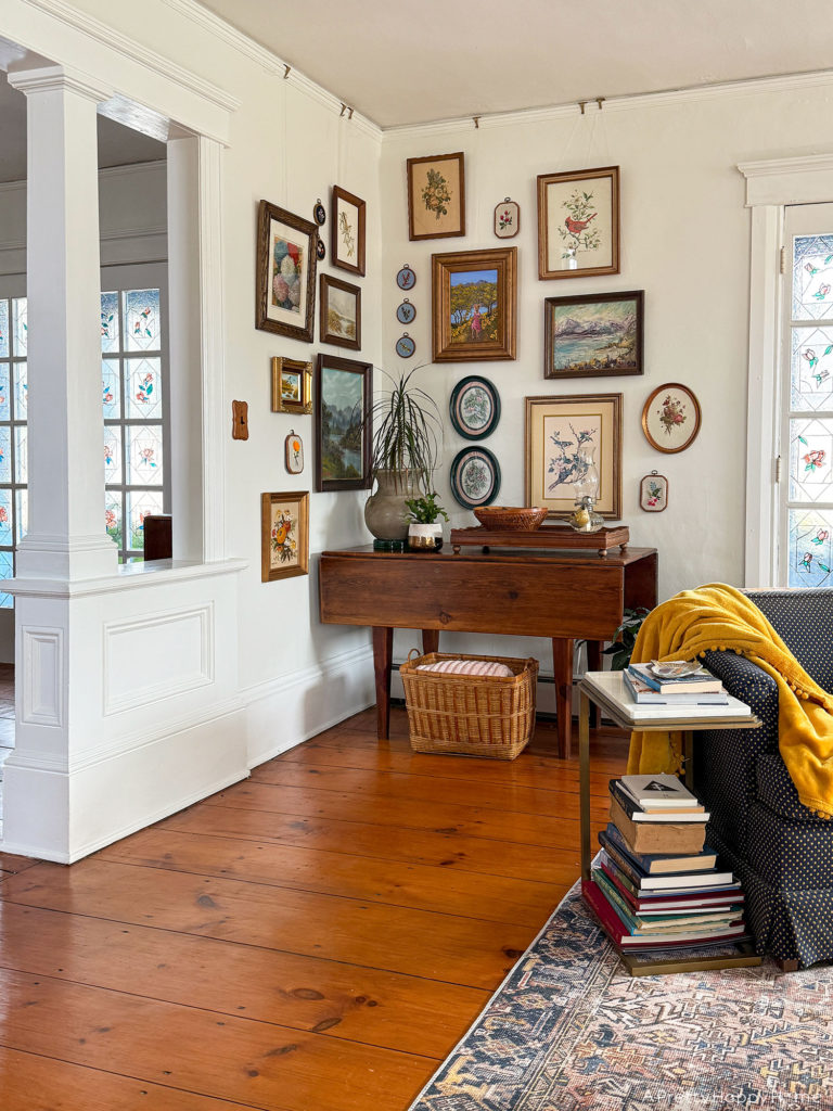 nature art gallery wall with paintings and embroidery next to stained glass doors gallery wall wrapping a corner