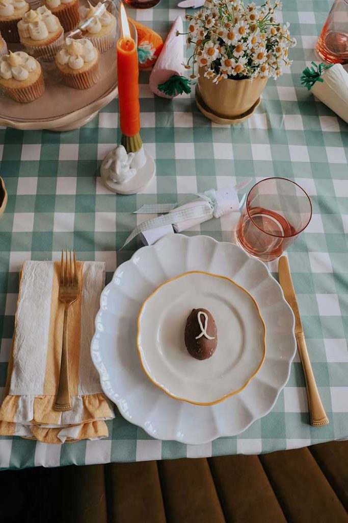 ways to make easter dinner special from nesting with grace table setting with cut daisies and chocolate egg piped with in initial in frosting on the happy list