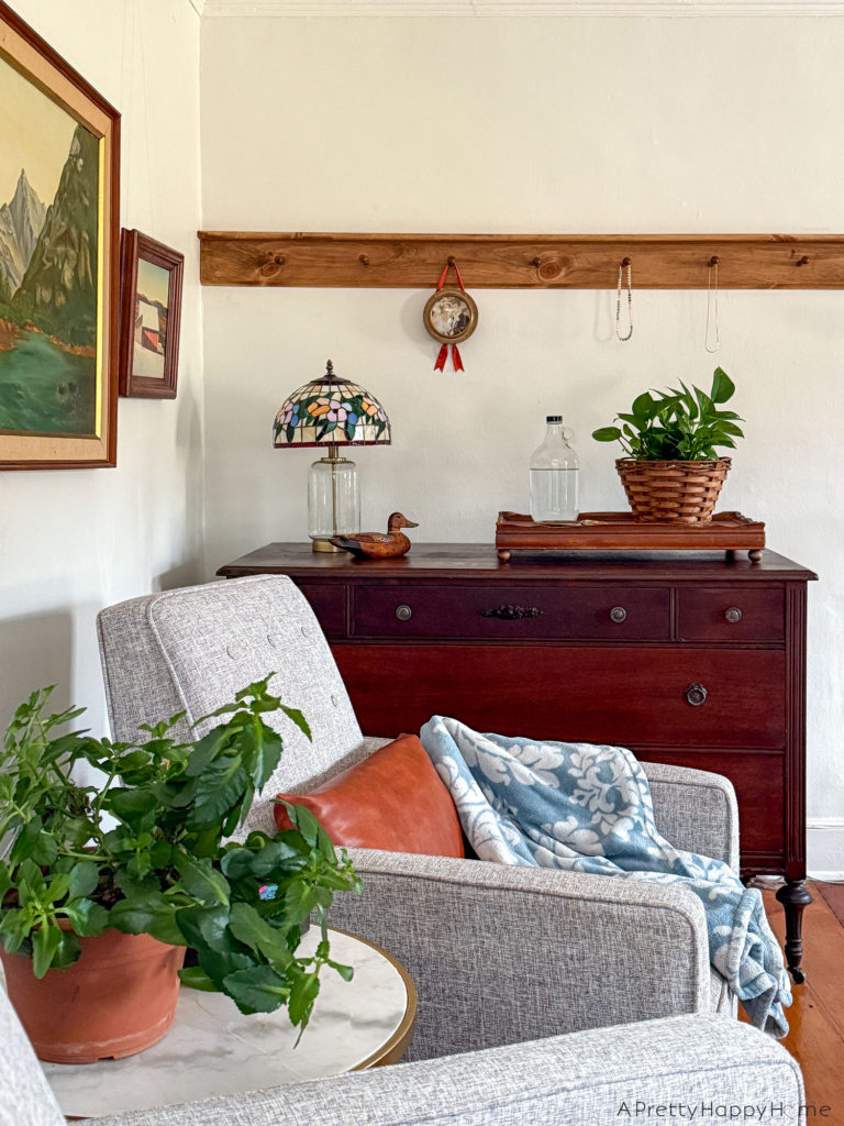 bedroom peg rail above a dresser in a colonial farmhouse with tiffany lamp