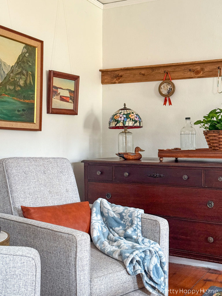 bedroom peg rail above a dresser in a colonial farmhouse with tiffany lamp