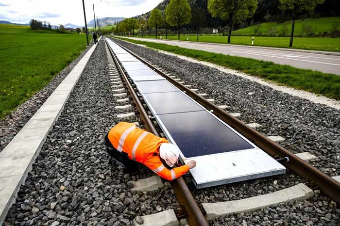 solar panels being installed on train tracks in switzerland image Keystone / Jean-Christophe Bott via swiss info on the happy list