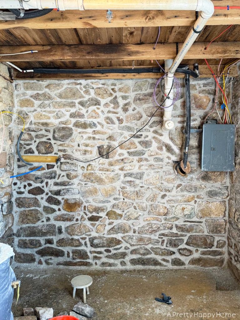 repointing a stone wall with old pipes embedded in the wall Stone Carriage House Gym: Part 4