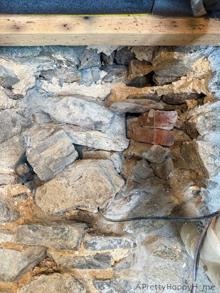 repointing a stone wall with old pipes embedded in the wall Stone Carriage House Gym: Part 4