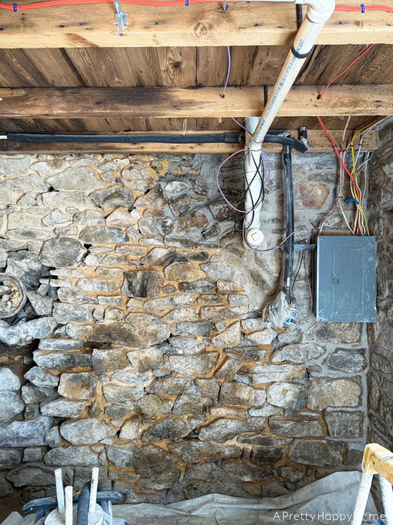 repointing a stone wall with old pipes embedded in the wall Stone Carriage House Gym: Part 4