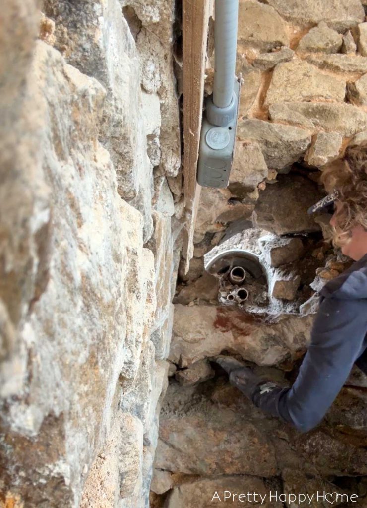 repointing a stone wall with old pipes embedded in the wall Stone Carriage House Gym: Part 4