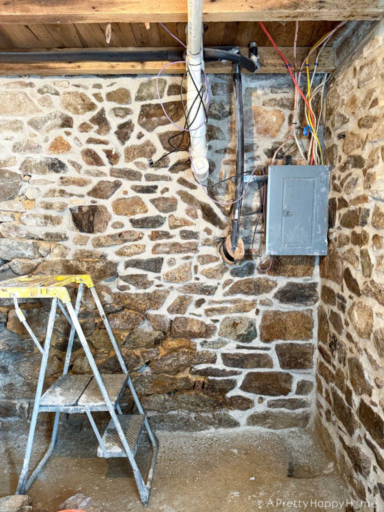 repointing a stone wall with old pipes embedded in the wall Stone Carriage House Gym: Part 4