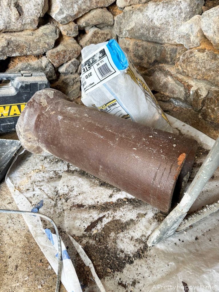 repointing a stone wall with old pipes embedded in the wall Stone Carriage House Gym: Part 4